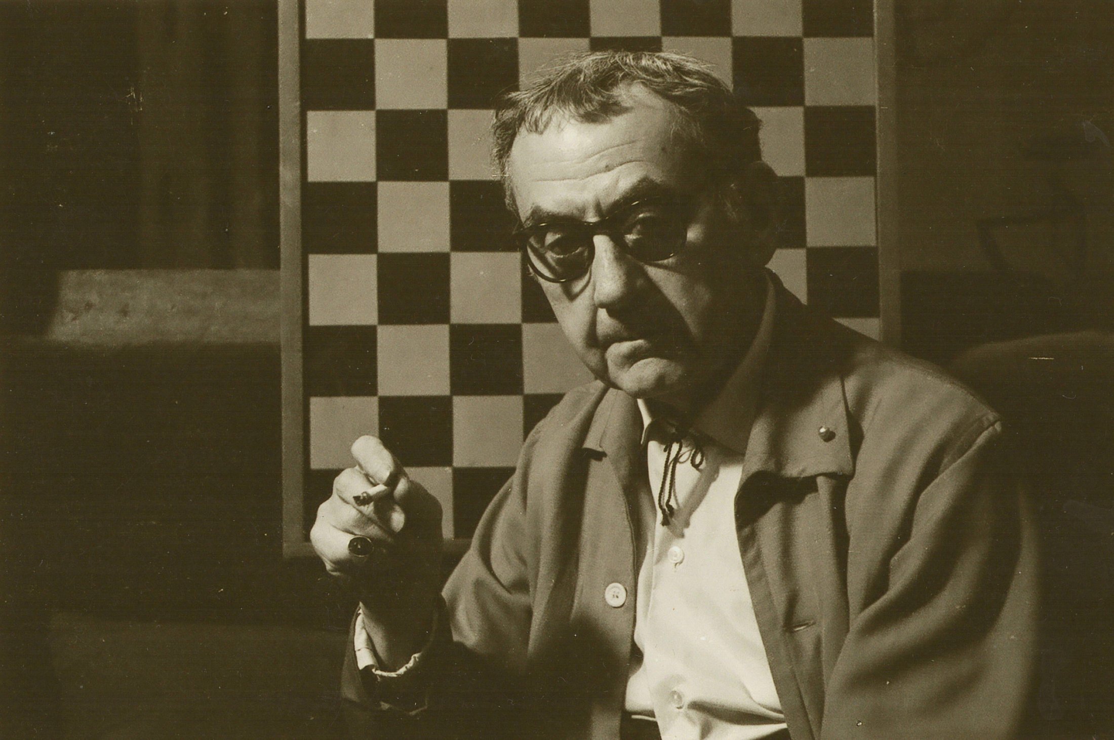 Man Ray against the chess board on which he played Marcel Duchamp 1964 by Andrew Lanyon