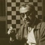 Portrait of photographer Man Ray against his chess board